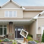 Renewal by Andersen employee carrying a window into a home