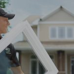 a man carrying a window out of a truck